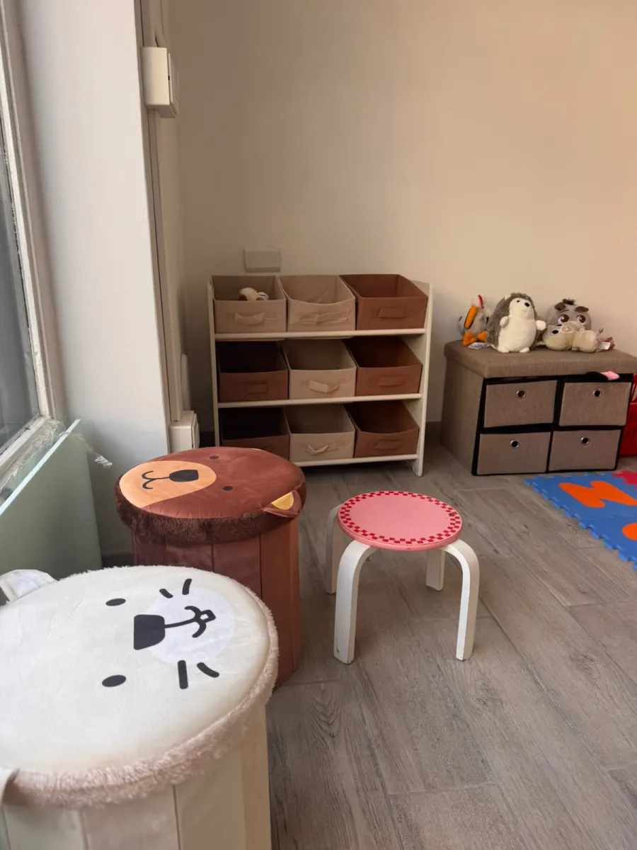 Angolo con pouf, sgabelli e ceste per i giochi dei bambini
